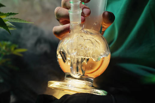 Person using a glass bong with water bubbling